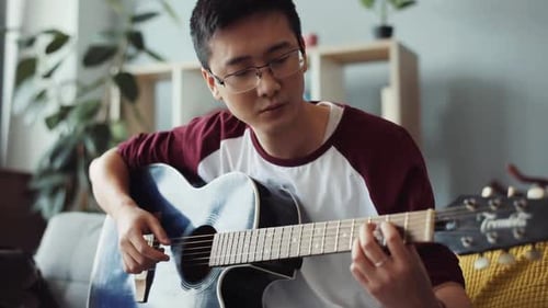 Man Plays Acoustic Guitar at Home, Close-Up