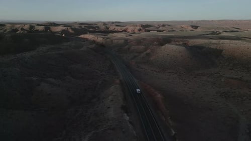 In the barren expanses of Utah, USA, a camper truck journeys through the desolate landscape, embodyi