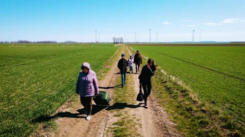 Aerial View Sad Family of Ukrainian Refugees Walking to Border with Poland By Country Road