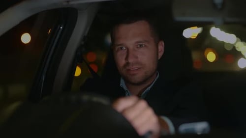 Man Driving Car at Night in City