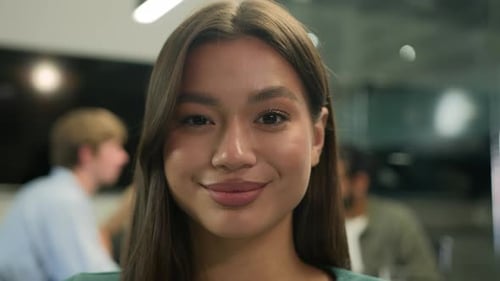 Smiling Woman Winks in Modern Office Setting