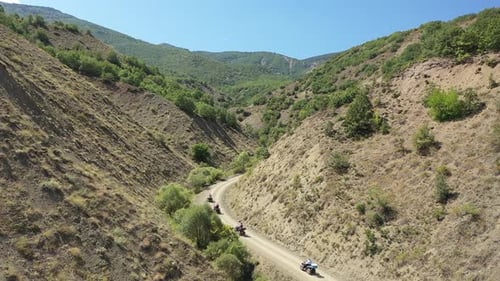 Aerial View Of Group Of People Riding On All Terrain Quadricycle Vehicle On Mountain Road