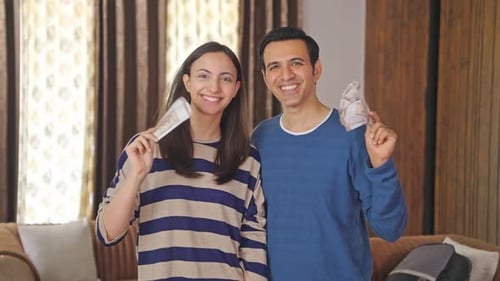 Happy Indian couple using money as fan