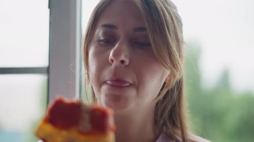 Woman Enjoys Slice of Pizza Indoors, Close Up
