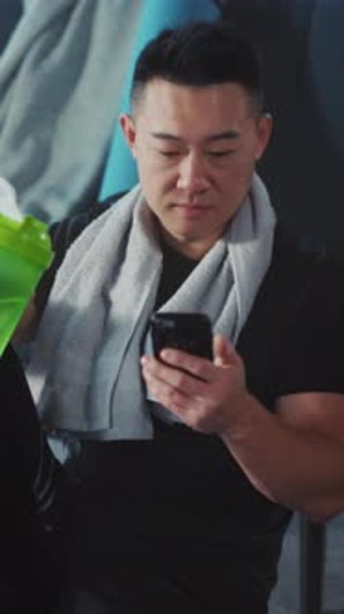 Asian Male Monitors Exercise Progress Peacefully Quiet Gym Scene with Man Tracking Workout Steps