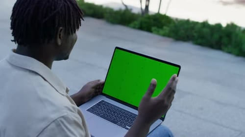 Man on Video Call with Green Screen Laptop