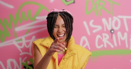 Excited woman laughing and pointing at the camera