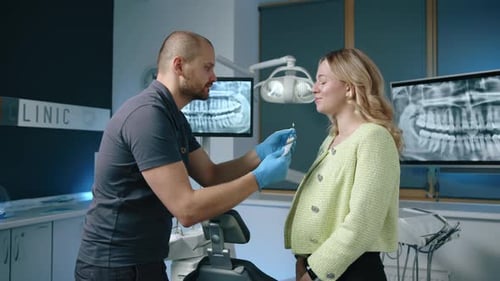 Dentist Showing Model to Patient in Clinic