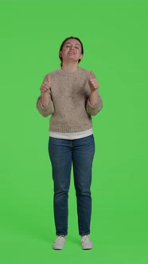 Vertikale Video-Frontansicht eines lächelnden Mädchens beim Thumbs Up Schild auf Greenscreen-Hintergrund