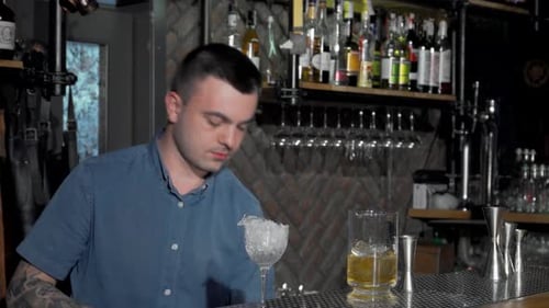 Skilled Bartender Expertly Crafting a Vibrant Cocktail at the Bar
