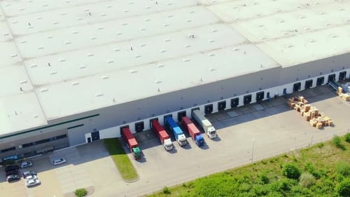 Buildings of logistics center, warehouses near the highway, truck parking process, view from height,