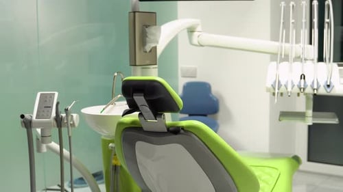Dental Chair with Modern Equipment Placed in Spacious Office with Cabinets and Various Tools in