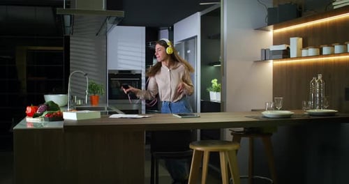 Young Woman Dancing and Singing in Kitchen