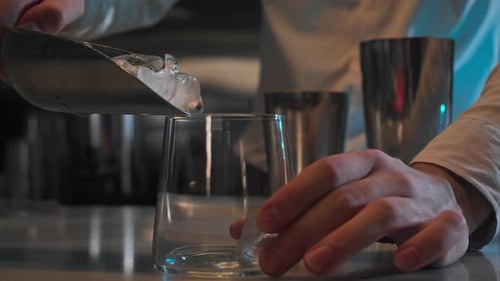 Ice Cubes Fall Into a Glass From a Spatula at the Bar in a Nightclub