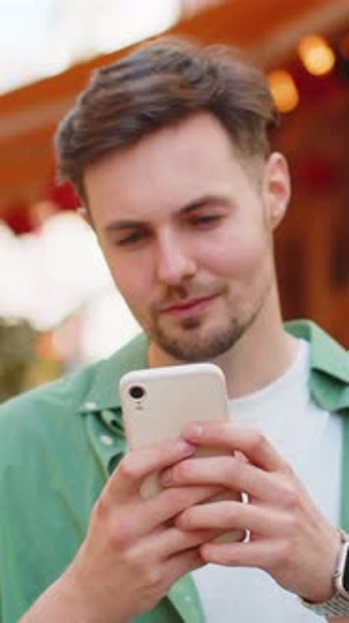 Smiling Young Man Using Smartphone outdoors