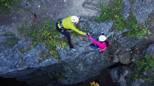 Couple Training Aerial Shot of Male Alpinist Helping Young Woman Reaching Mountain Top Climbing