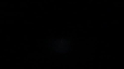 Flashes of lightning in the night sky among thunderclouds.