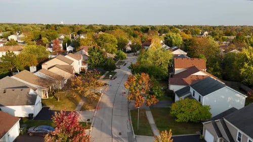 Aerial View of Suburban Street in Autumn Vibrant Homes and Trees Along Quiet Roads