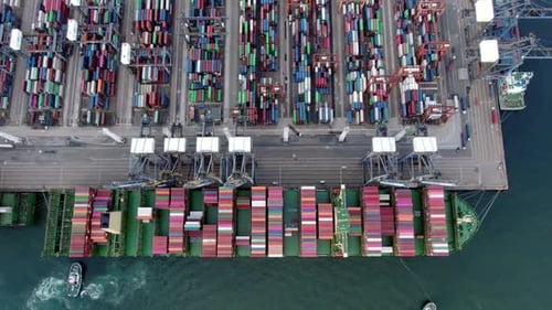 Mega Container Ship docked at Hong Kong port, during loading and unloading operation, Aerial view.