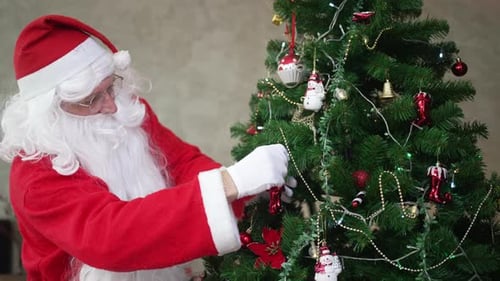 Man in Santa Suit Decorating a Christmas Tree