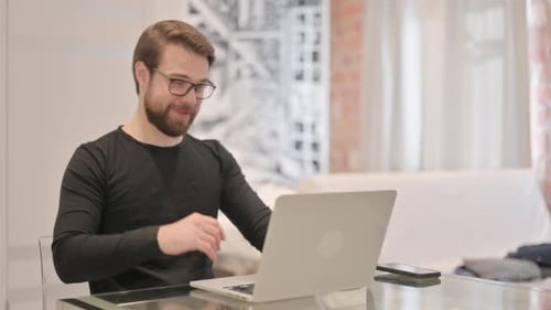 Man On Laptop Doing Video Call At Desk