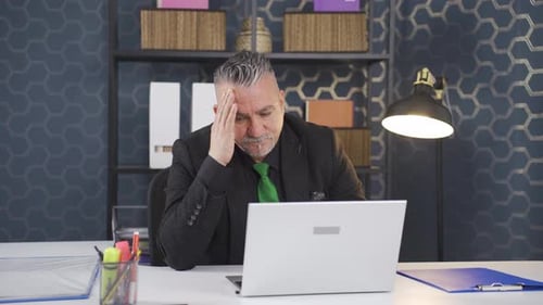 Confused Man in Office Sitting at Desk