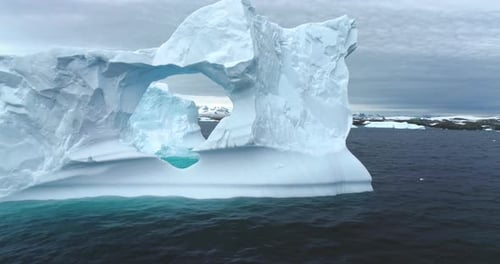 Majestic Iceberg with Archway Floating in the Ocean