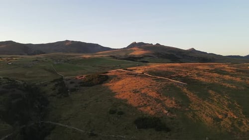Drohnenaufnahme der Alpen bei Sonnenuntergang mit Hütten und Ackerland, wunderschöne Natur. Mitten in
