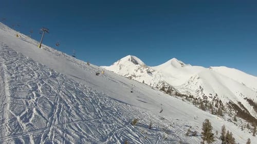 Ski slope with ski lift and mountain in the background on a sunny day