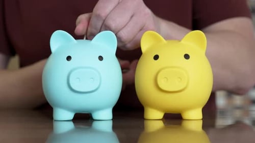 Man inserting coins into two piggy banks: savings and investment
