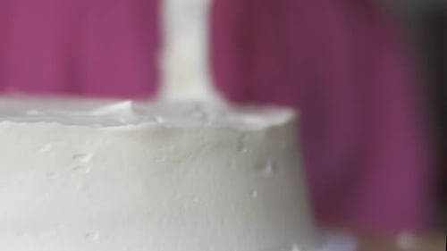 Spreading Buttercream Frosting To Evenly Coat Cake Using Frosting Spatula. closeup