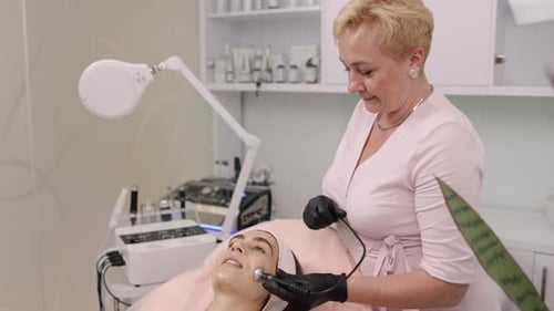 Woman receiving facial treatment in bright medical office