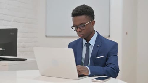 Jeune professionnel travaillant assidûment sur un ordinateur portable