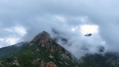 Mountain Peaks Shrouded in Clouds Drone Footage