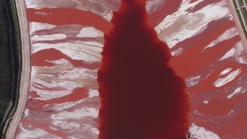 Aerial view of a massive red mud pond on the coast, an industrial waste byproduct from alumina
