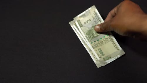 Um homem contando rúpias indianas.