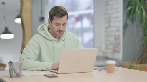 Man Working on Laptop at Modern Desk