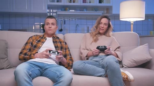 Couple Playing Video Games at Home at Night