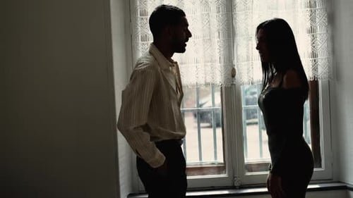 Silhouetten eines Paares, das sich heftig streitet. Freund schubst Freundin mit der Hand. Inländisch