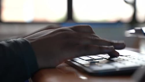 Imagem aproximada da mão preta digitando no teclado 4K