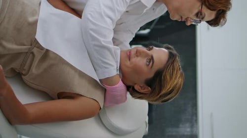 Cosmetologist Preparing Woman to Beauty Procedures in Modern Clinic Vertical