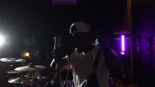 Young african american singer recording music in professional studio
