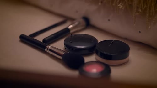 A Range of Makeup Items and a Selection of Brushes are Neatly Arranged on a Dressing Table