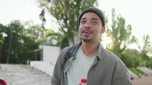 Multiracial Group of Friends Enjoying a Sunny Day Outdoors at a Park While Engaging in Conversation