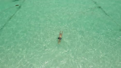 Man swiming breaststroke on clear ocean water in slow motion