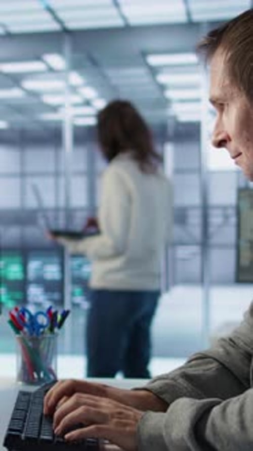 Man Typing at Computer in Bright Tech Office
