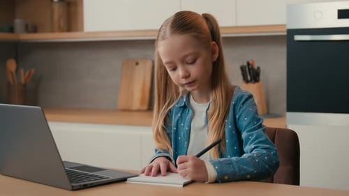 Caucasian School Girl Studying at Kitchen Online with Laptop Write Exercise Distant Elearning