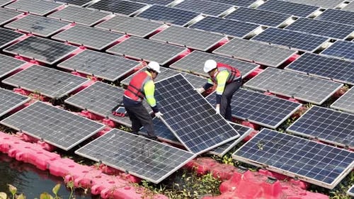 Painel solar flutuante na lagoa. O trabalhador faz o serviço e verifica os painéis solares fotovoltaicos flutuantes
.