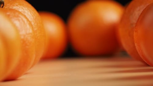 Camera movement along tangerines on a black background.