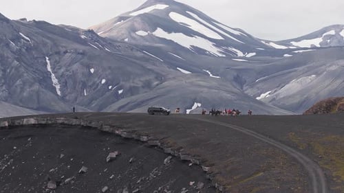 Group on Horseback and Vehicle Moving in Iceland's Volcanic Highlands